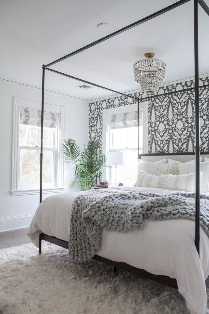 black and white wall paper and black wrought iron 4 poster bed