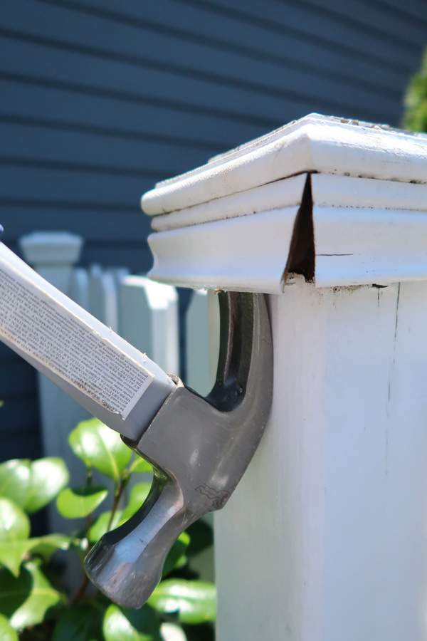 using-the-hammer-claw-pry-off-sides-of-deck-or-fence-post-cover