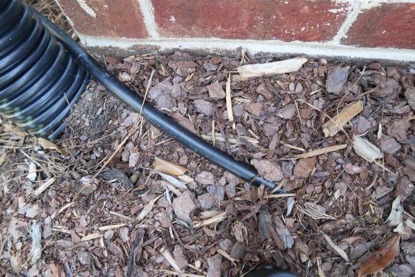 Run 1:2 inch tubing around foundation and under mulch or dirt