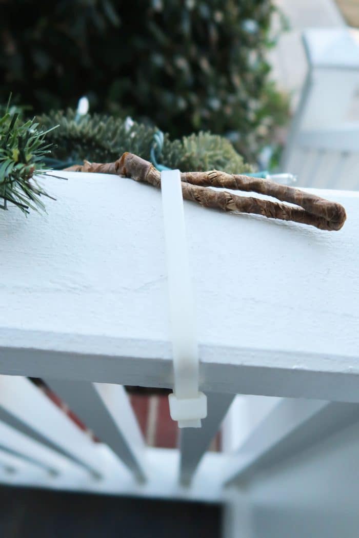 attach cable tie around railing and secure end of Christmas swag