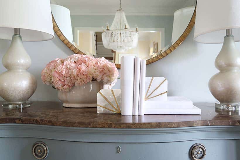 books wrapped in white craft paper with pink hydrangeas and white lamps