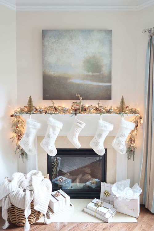 narrow-mantel-with-simple-Christmas-decor-in-neutral-colors-with-wrapped-packages-white-stockings