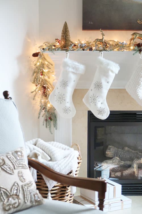 white-stockings-hanging-christmas-mantel-lights-packages