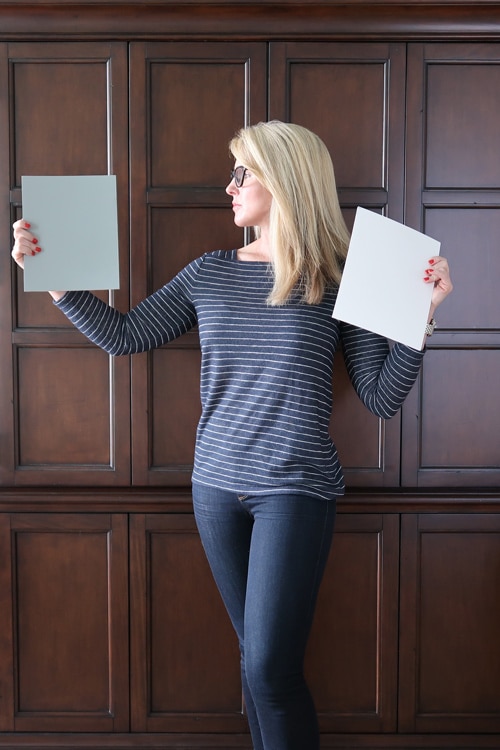 How-to-choose-a-paint-color-for-cabinets-or-a-large-piece-of-furniture_woman-in-front-of-armoire-holding-paint-samples