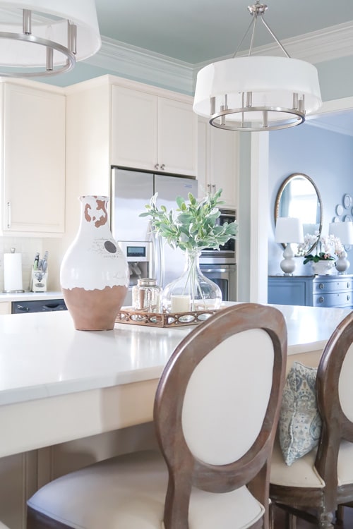 White-Quartz-Kitchen-Island-Looking-Into-Blue-Dining-Room-Round-Mirror