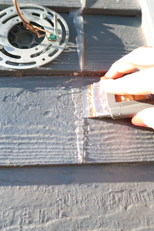 flat-blade-scraping-off-silicone-from-exterior-siding