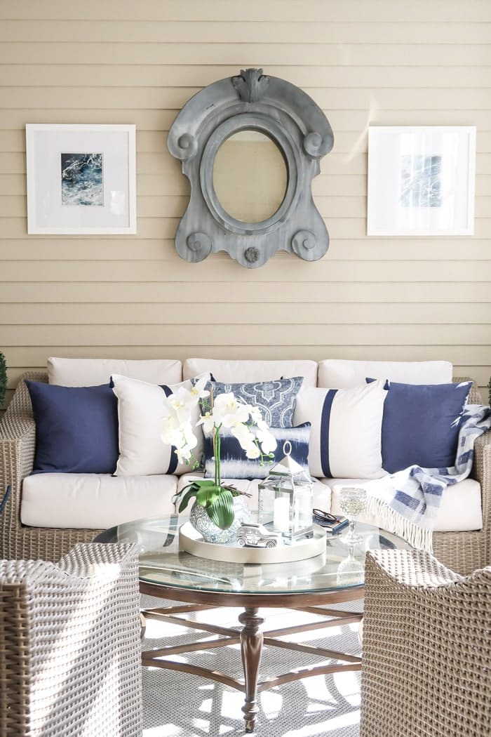 driftwood-outdoor-sofa-chairs-round-coffee-table-white-and-navy-pillows-min