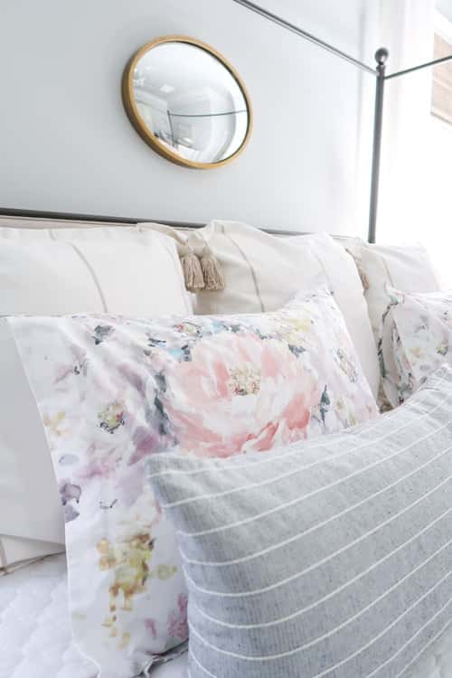 close-up-of-floral-sham-on-king-sided-bed-with-blue-and-white-pillows