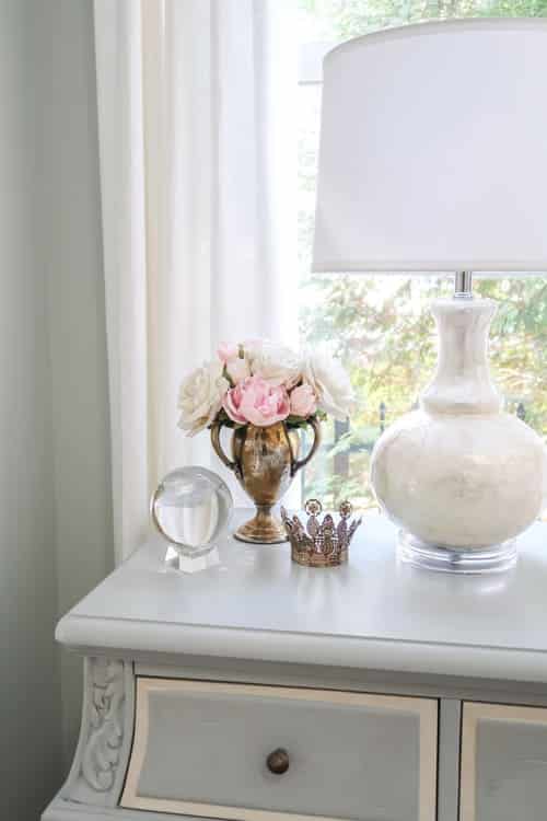 crown-pink-flowers-glass-paper-weight-white-lamp-on-blue-painted-nightstand
