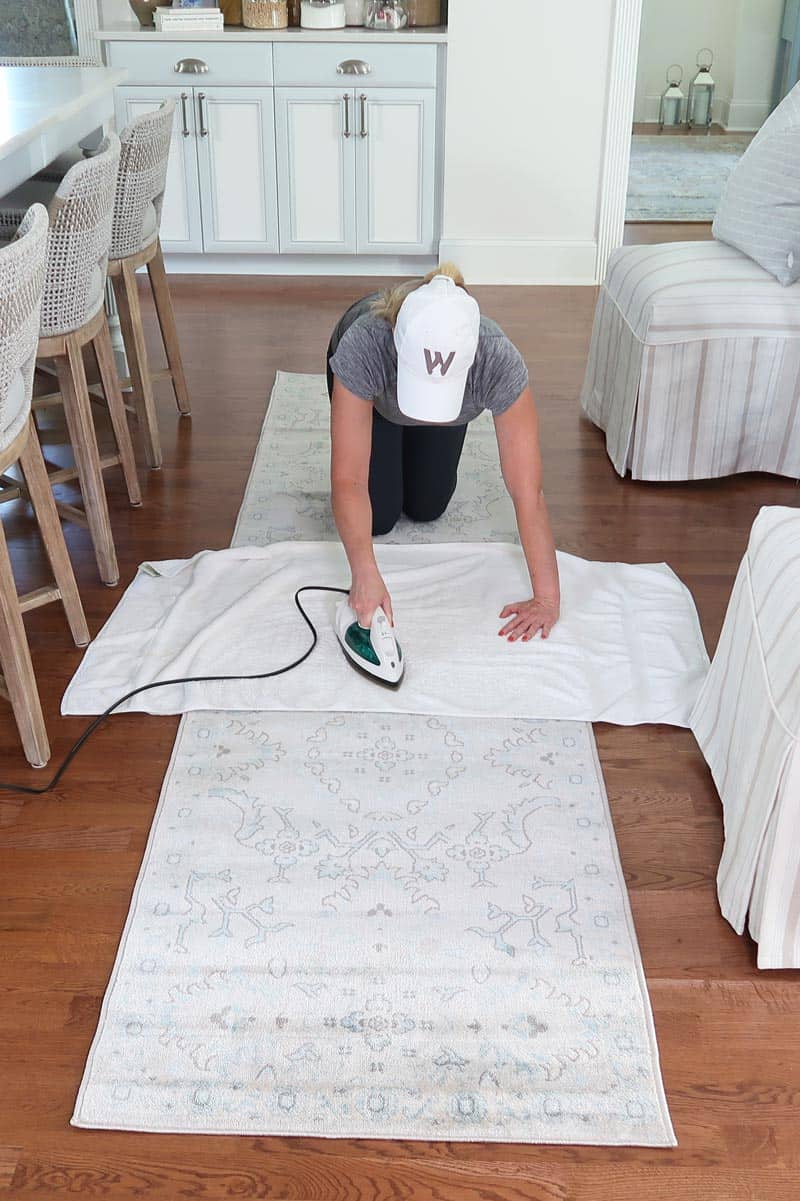 woman-ironing-rug-to-remove-wrinkles
