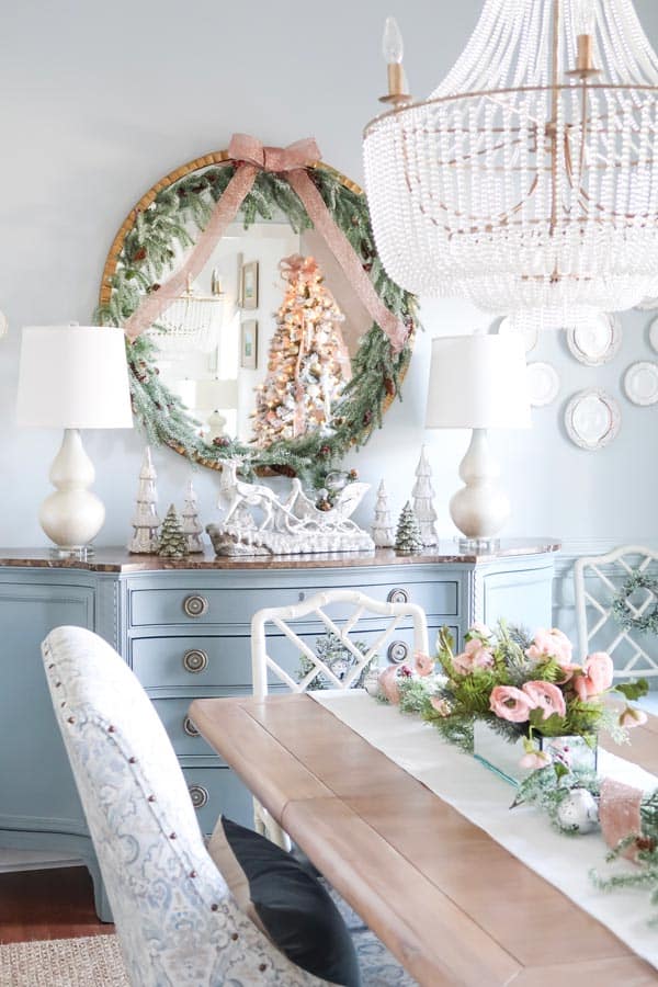 dining-room-table-decorated-with-pink-flowers-and-garland-round-mirrow-trimmed-in-garland