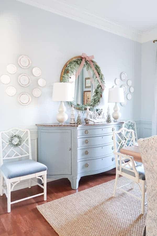 sideview-of-blue-credenza-velvet-covered-chairs-garland-trimmed-round-mirror