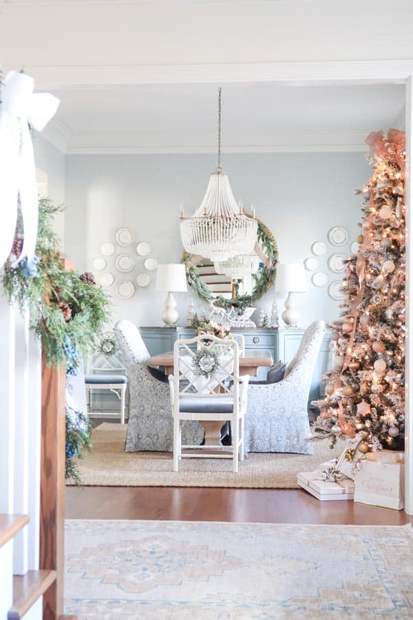 view-of-dining-room-with-decorated-tree-and-garland-on-the-stairs