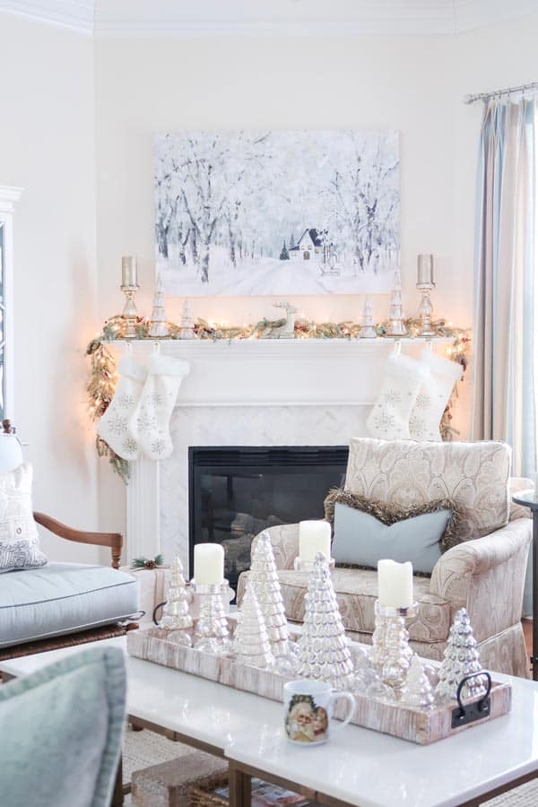 view-of-trees-on-coffee-table-and-mantel-with-stockings