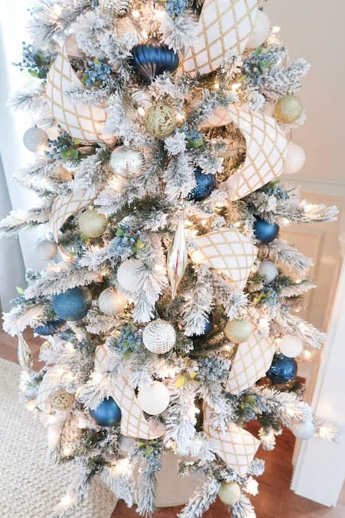decorations-close-up-flocked-christmas-tree-gold-blue-white-ribbon